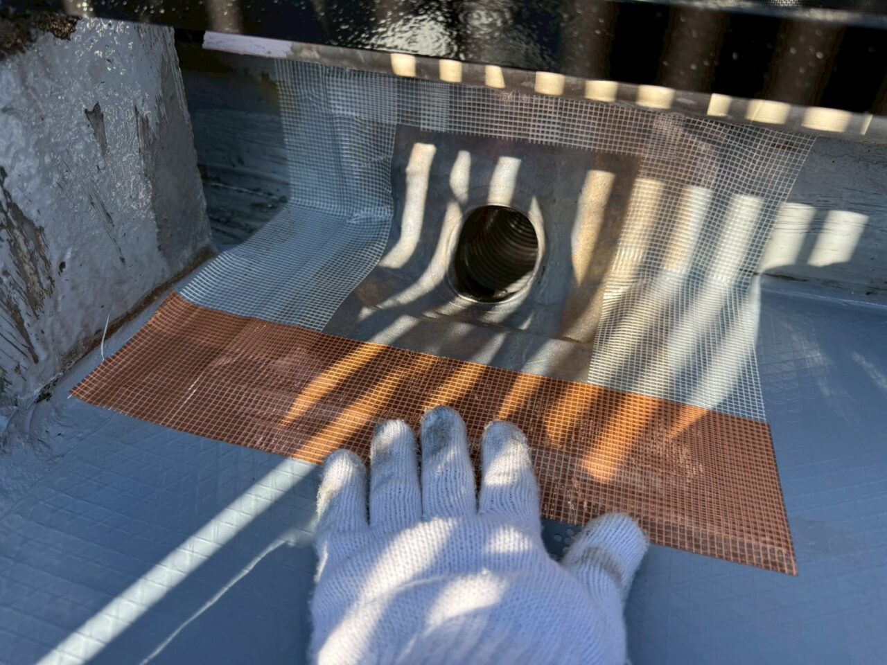 排水ドレン周辺にメッシュシートを設置して補強している様子