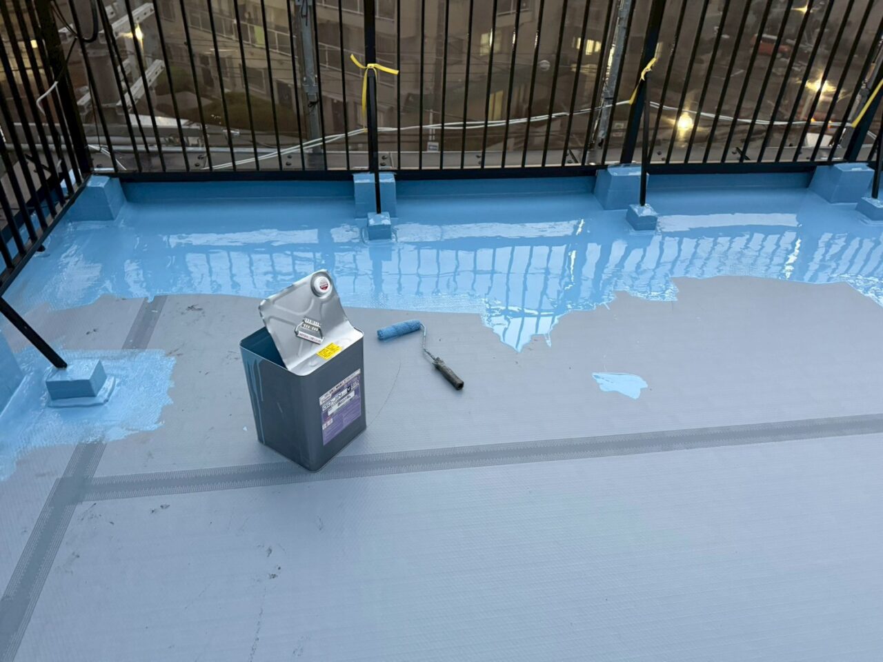 屋上防水工事で使用するウレタン防水材とローラーを置いた施工準備の様子（池田市事務所・通気緩衝工法）