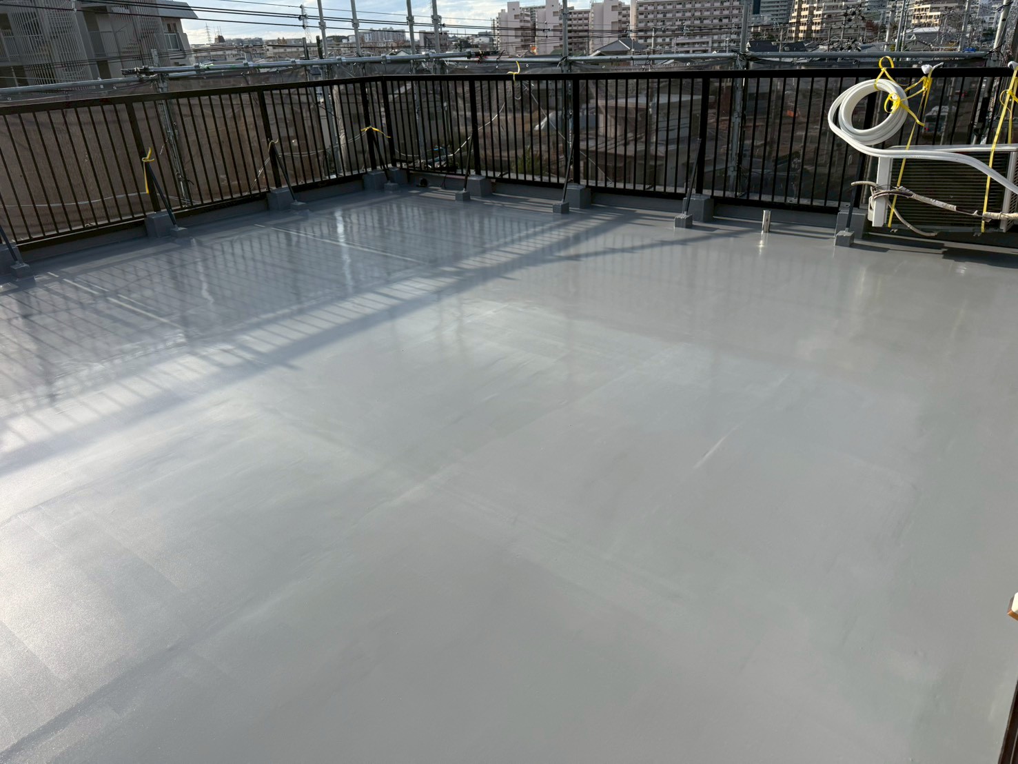 ウレタン防水塗布後の仕上がった屋上全体の様子、滑らかな表面仕上がり（池田市事務所の屋上防水）